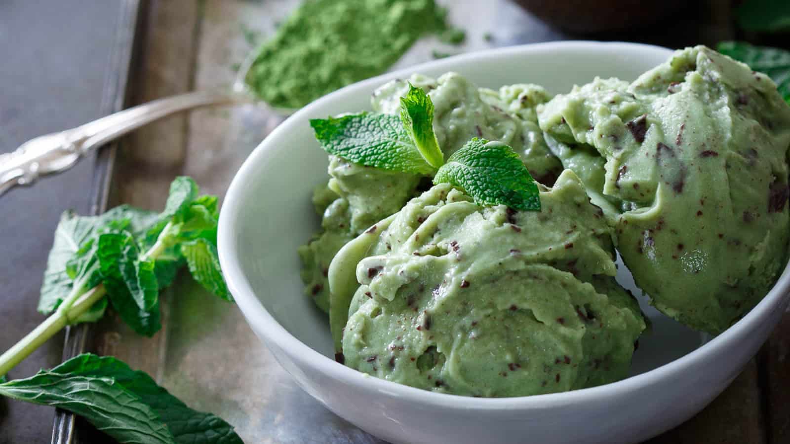 Matcha mint chocolate chip ice cream in a bowl with mint leaves and matcha.
