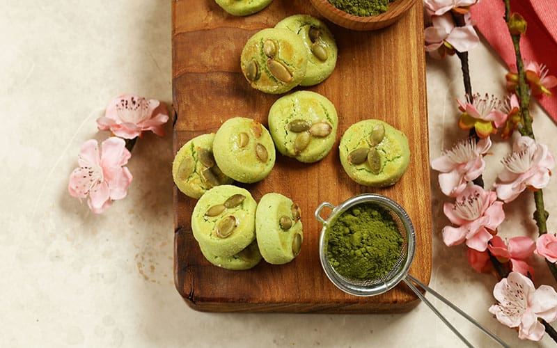Matcha sugar cookies on wooden block from above view.