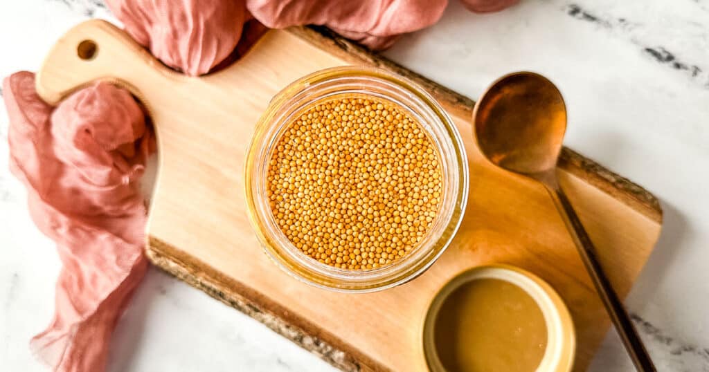 Overhead shot of pickled mustard seeds in a glass jar.