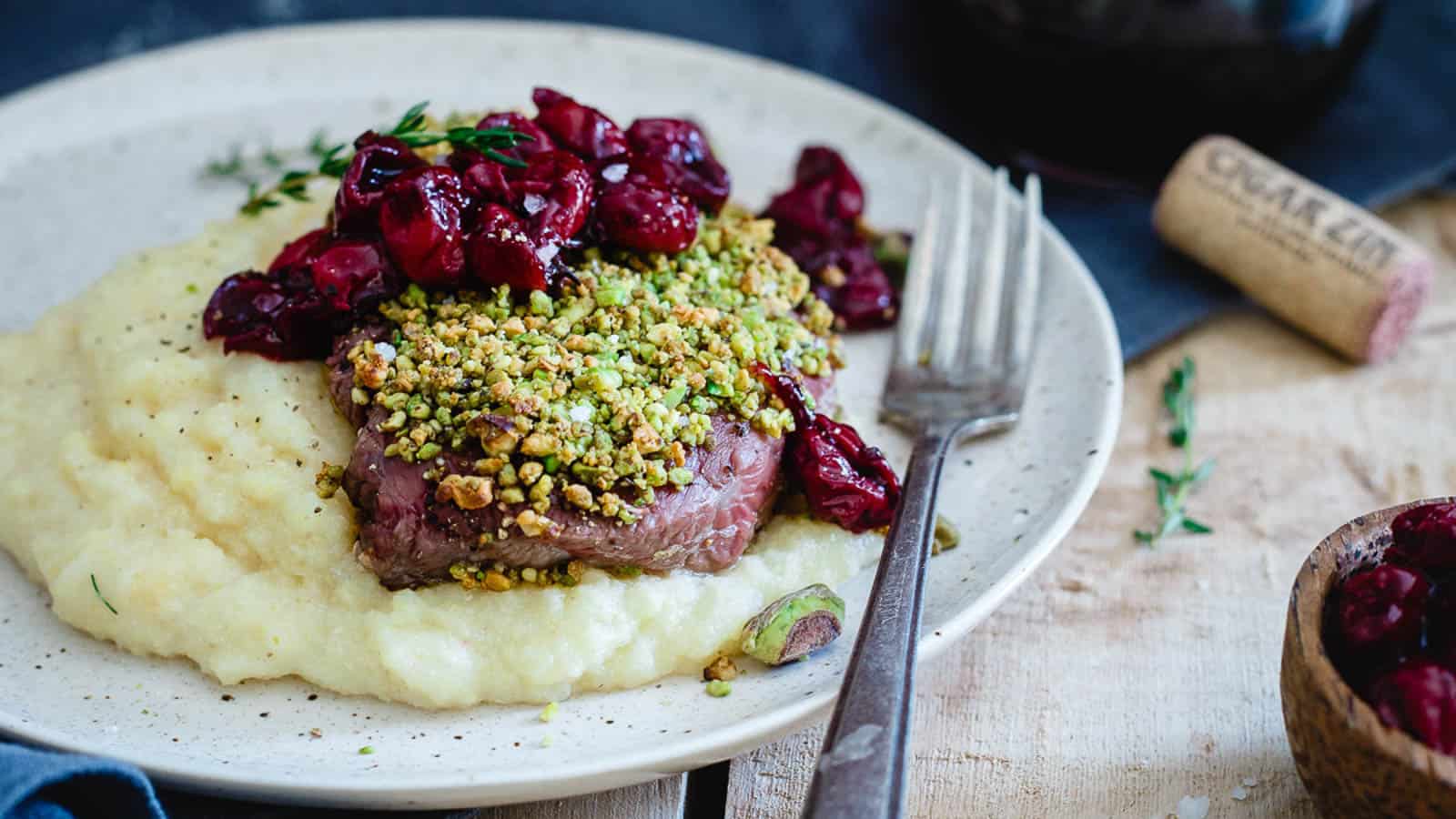 Pistachio crusted lamb chops served over mashed potatoes with cherry sauce.