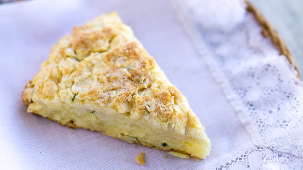 A wedge of savory scones with cheddar and garlic on a napkin.