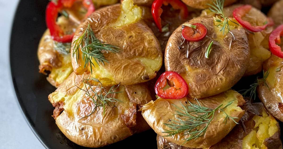 Air fryer smashed potatoes on a black plate.