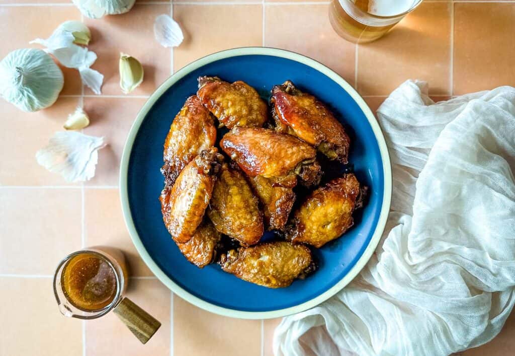 Soy garlic chicken wings on a blue plate.
