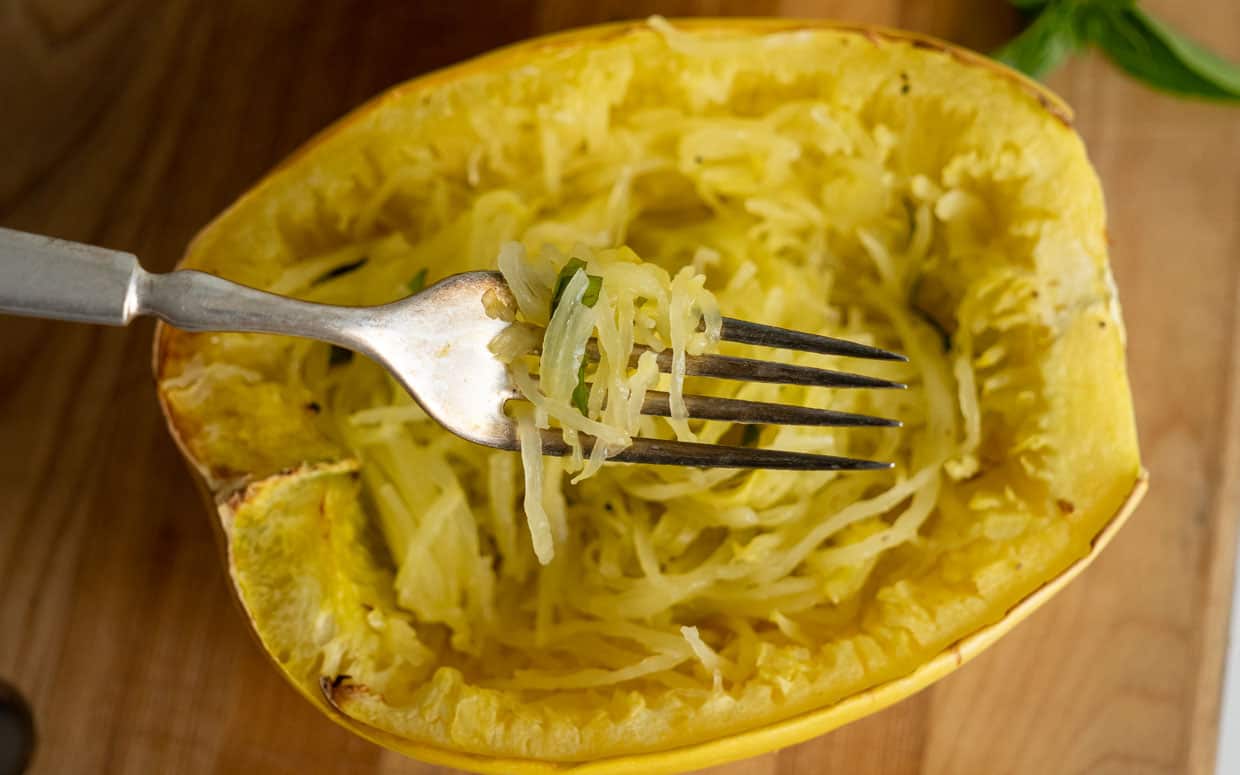 Top view of cooked spaghetti squash with some on a fork.