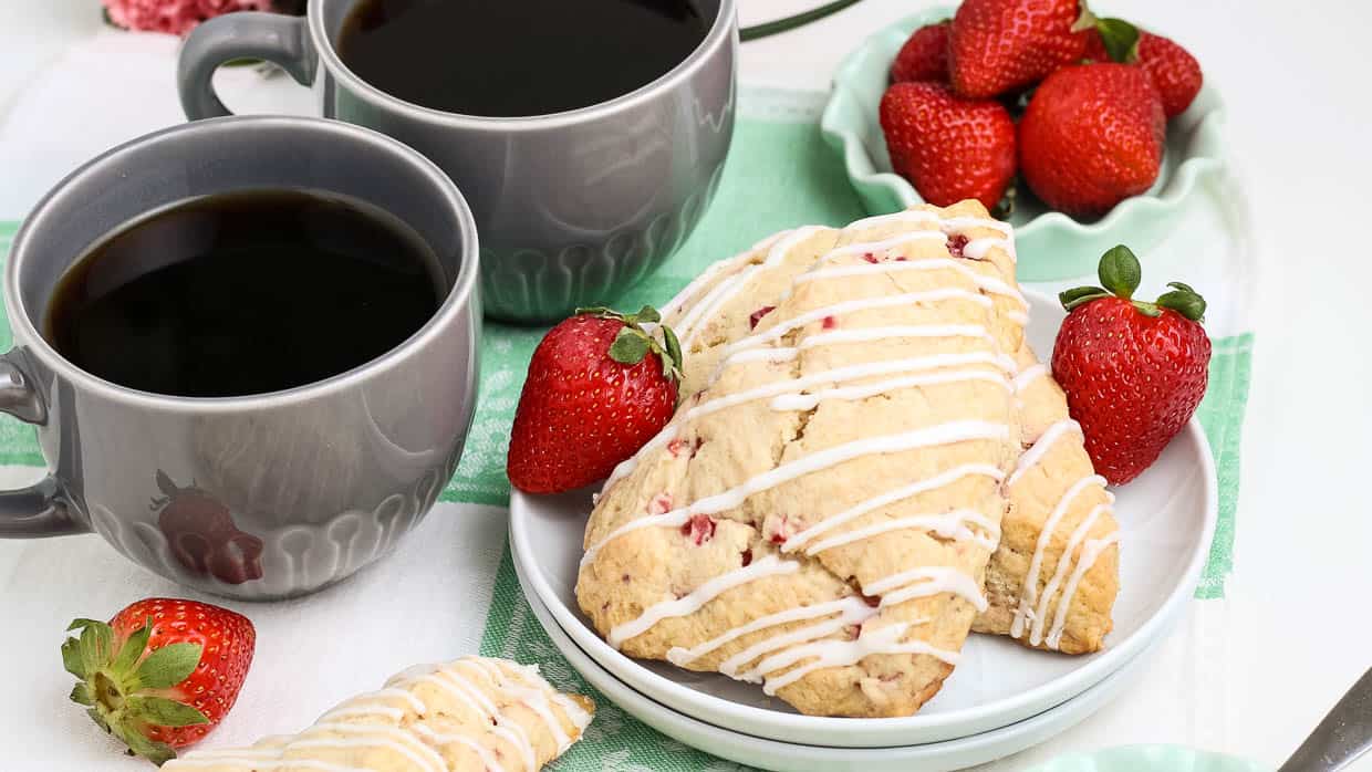 Strawberry scones on a plate with coffee on the side.