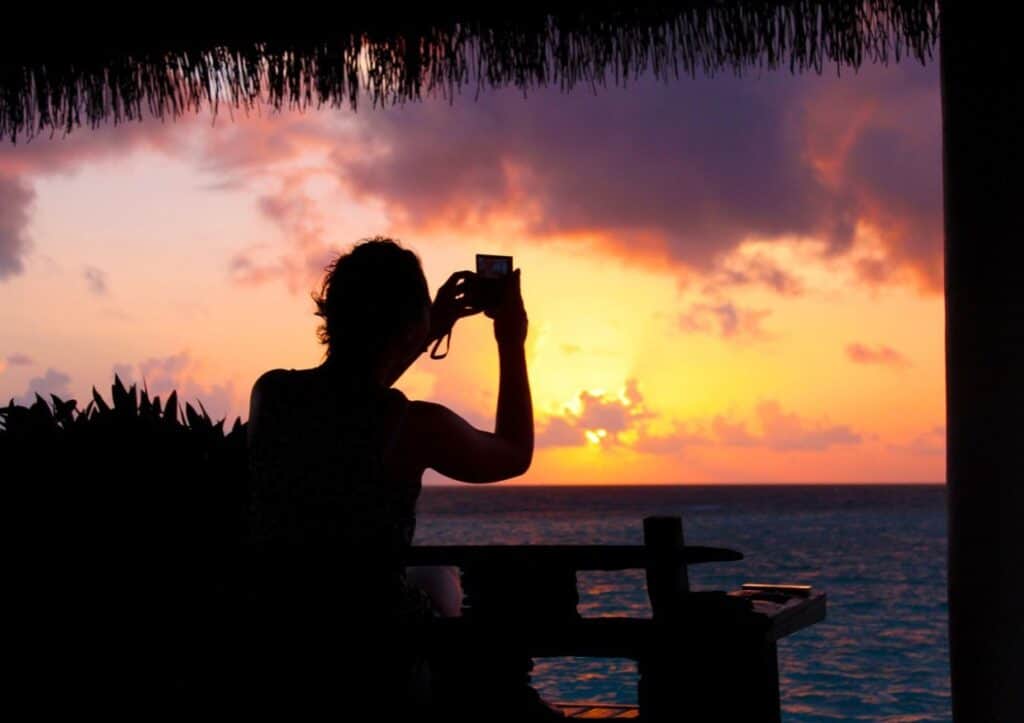 Man taking sunset photo with phone