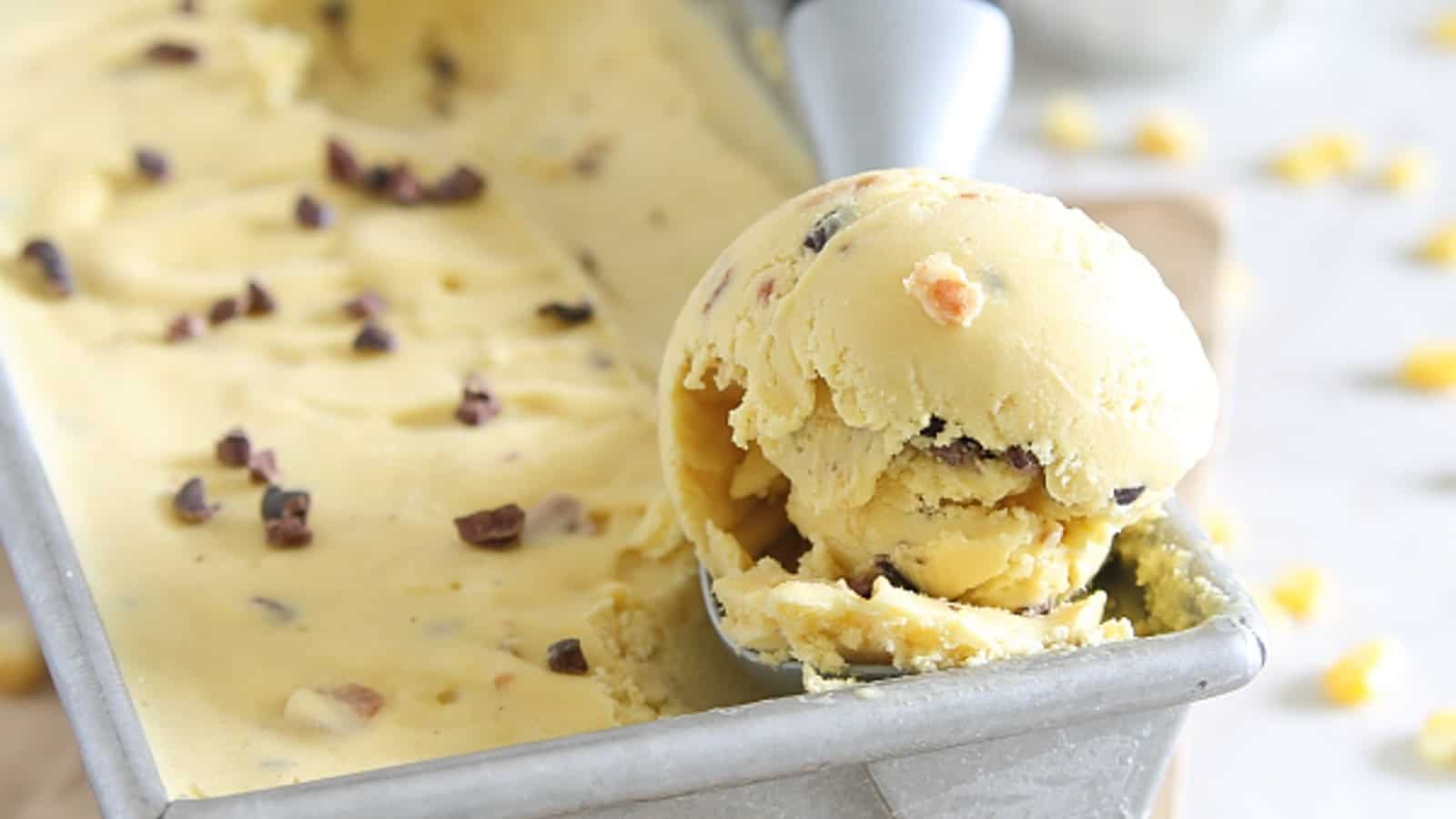 Sweet corn bacon ice cream in a tin with an ice cream scoop.