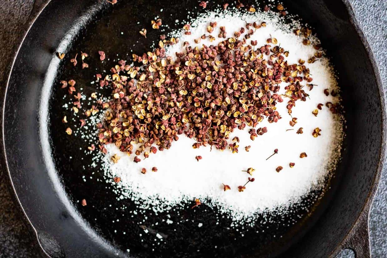 Sichuan peppercorns and salt in a cast-iron skillet.