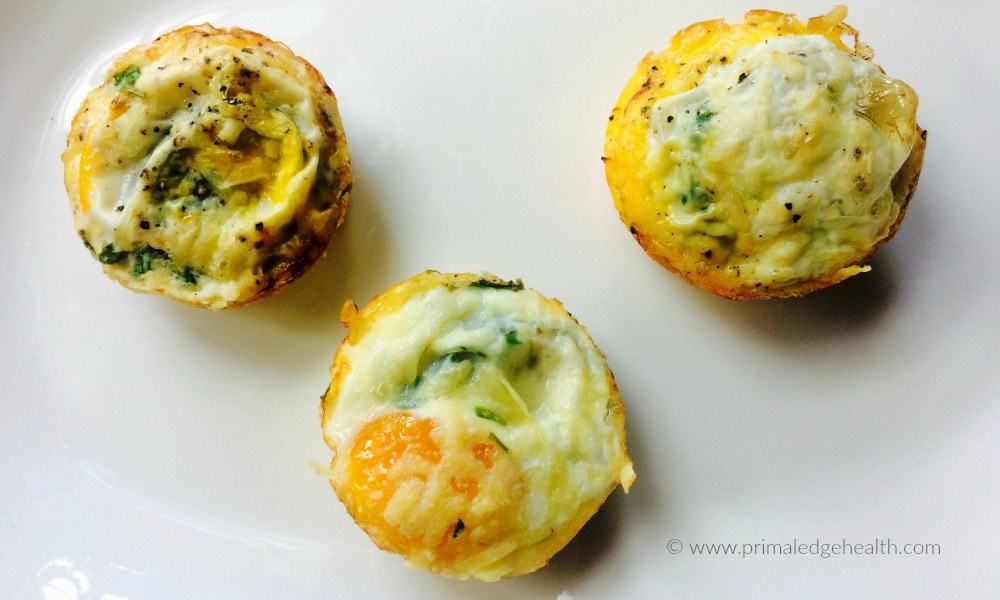 A picture of three tomato zucchini egg cups on white plate.