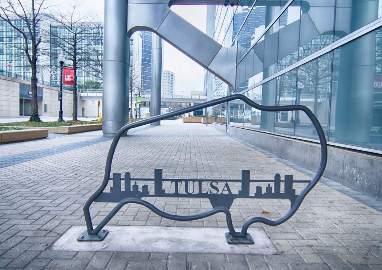 A decorative ironwork and partial view of the Tulsa skyline.