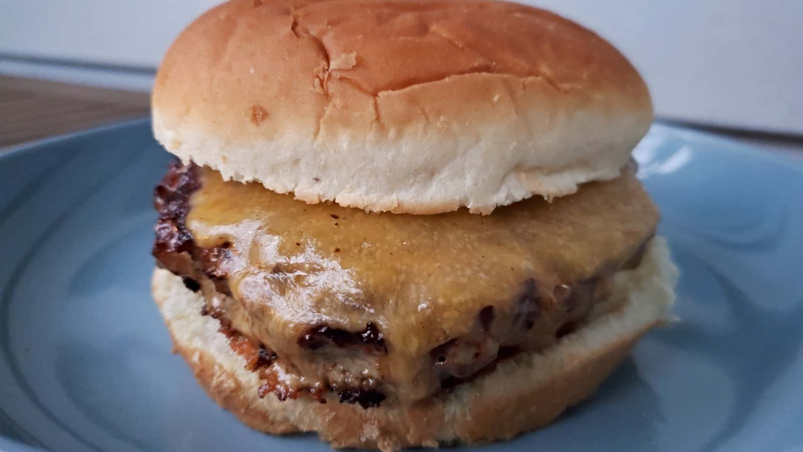 Image shows Asian inspired turkey burger on a blue plate.