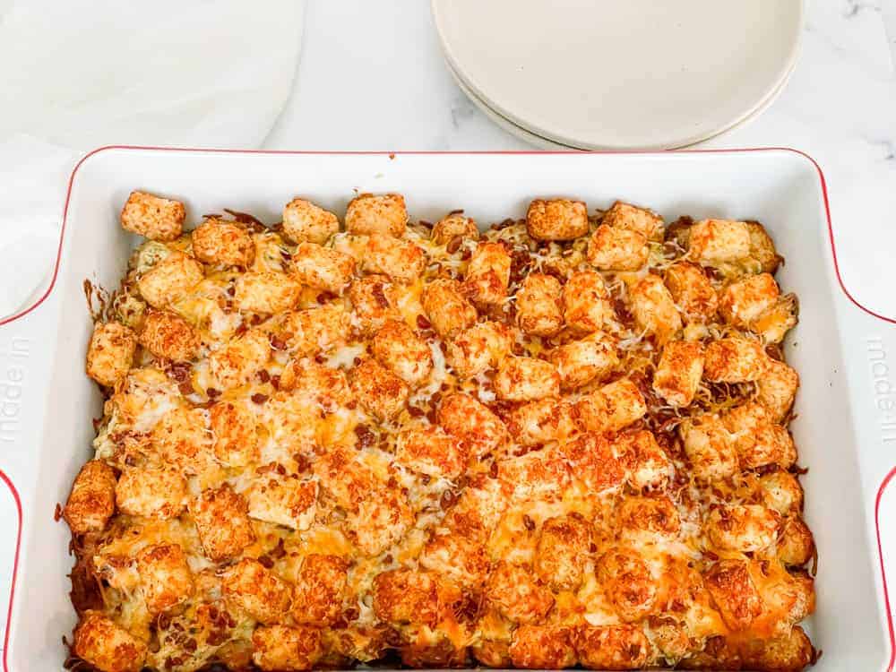 A pan of bacon ranch casserole topped with tater tots and cheese.