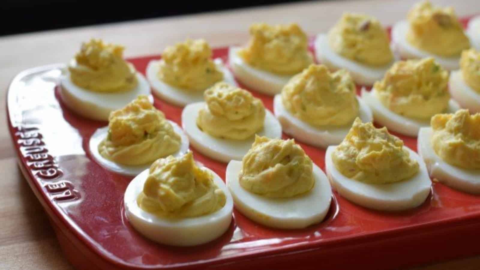 Bacon deviled eggs in a red platter.