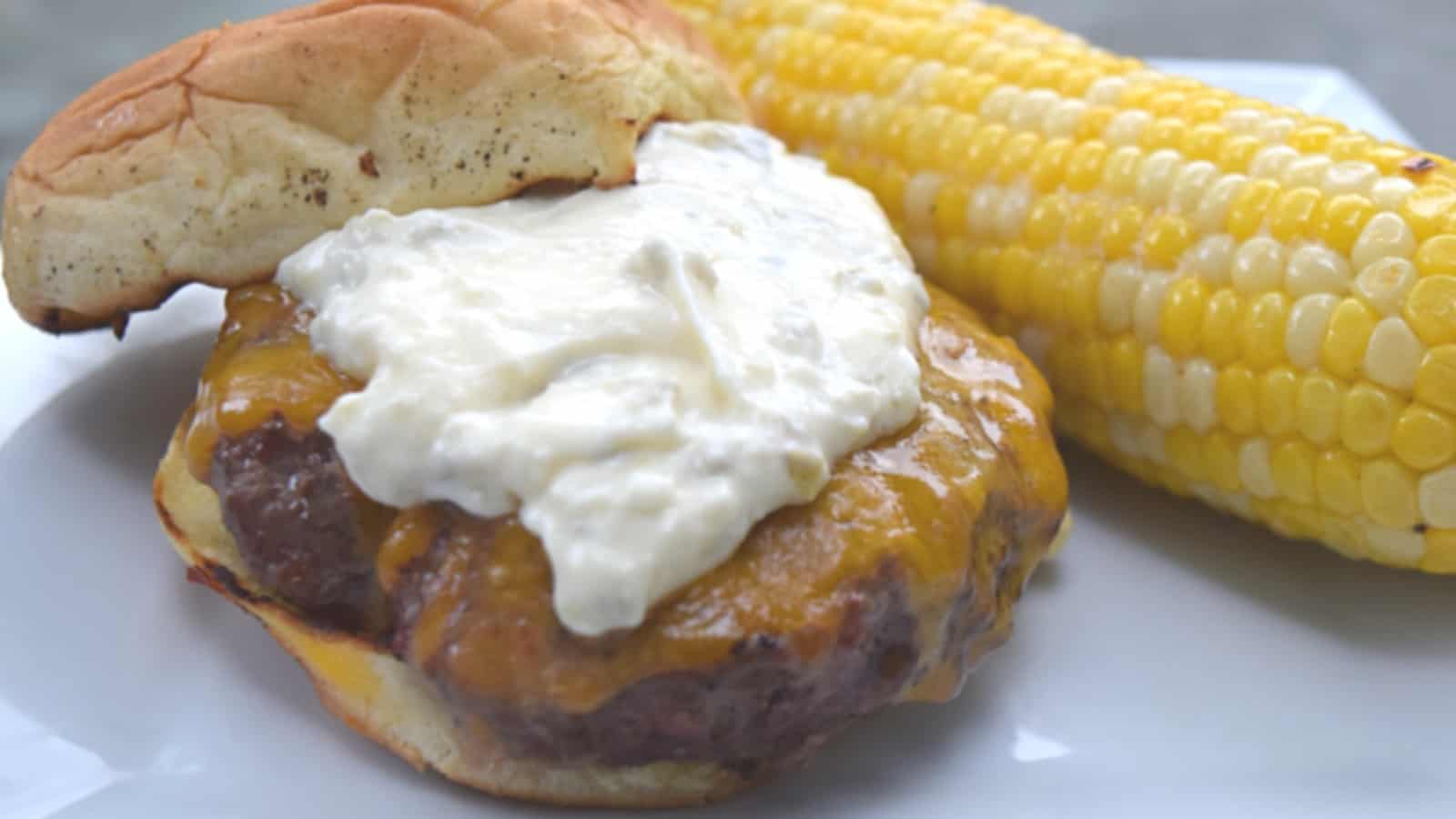 Image shows a Chipotle burger with grilled corn in the background.