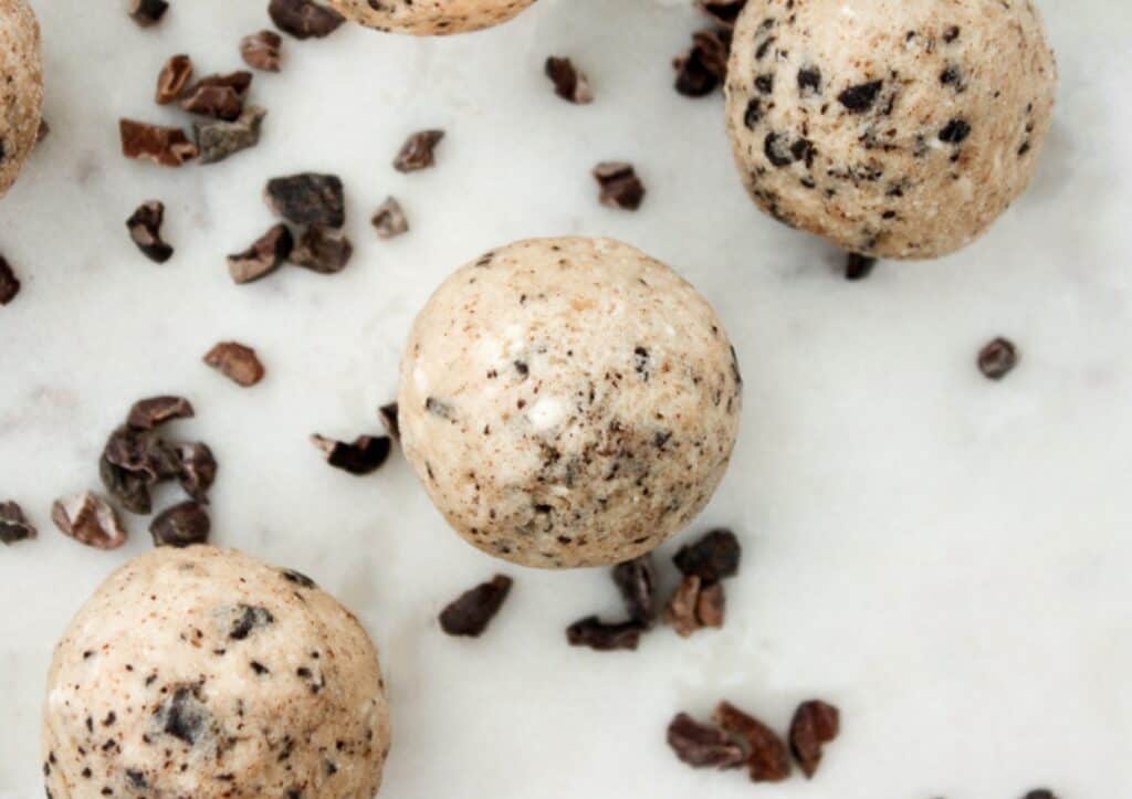 Three chocolate chip cookie dough fat bombs by chocolate chips.