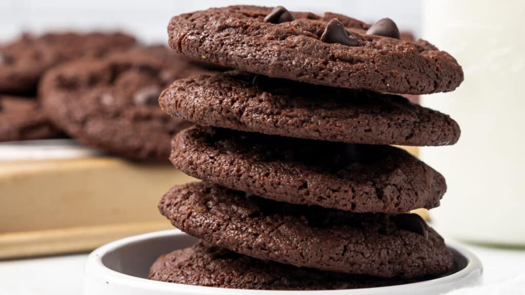 Chocolate chocoalte chip cookies in a white bowl.