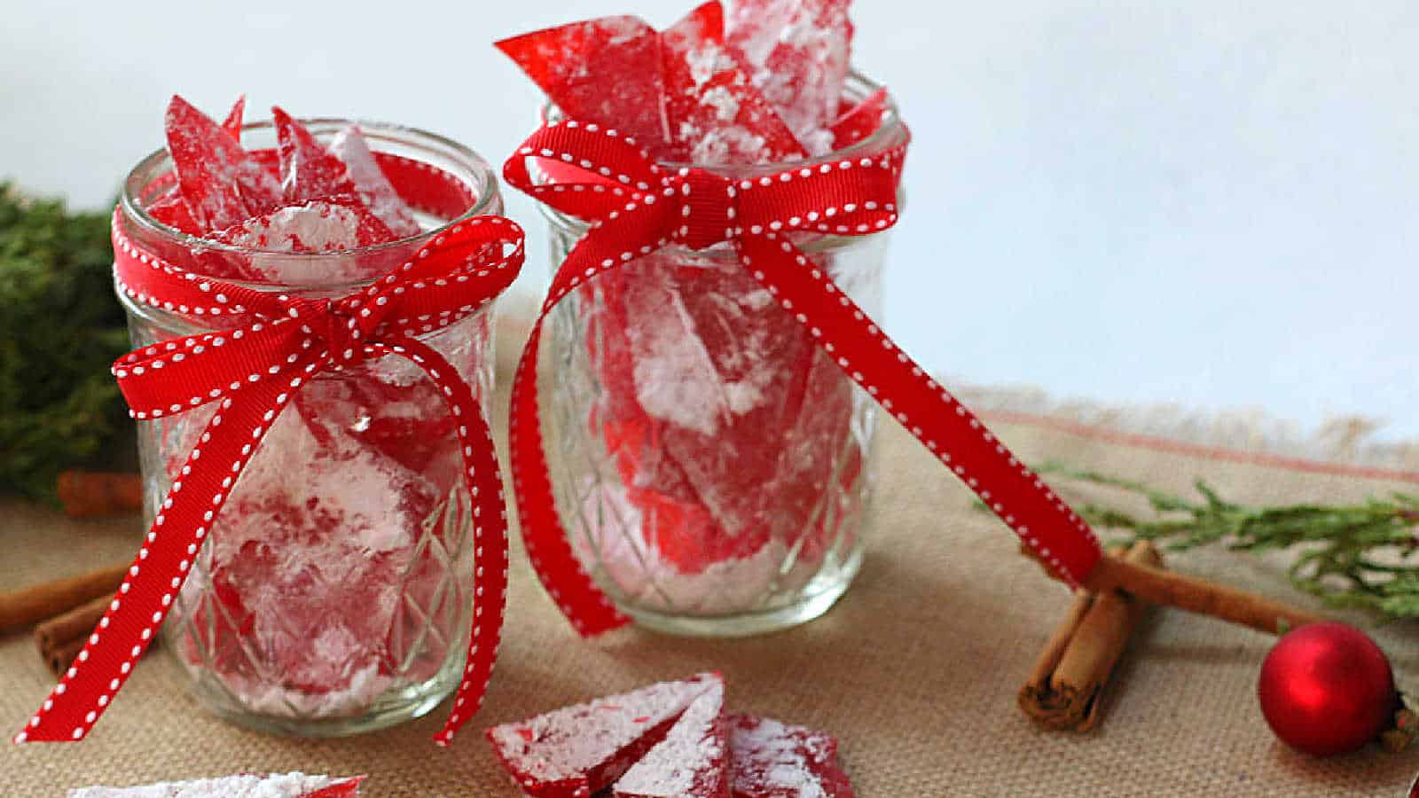 Cinnamon rock candy in glass jars with red ribbons.