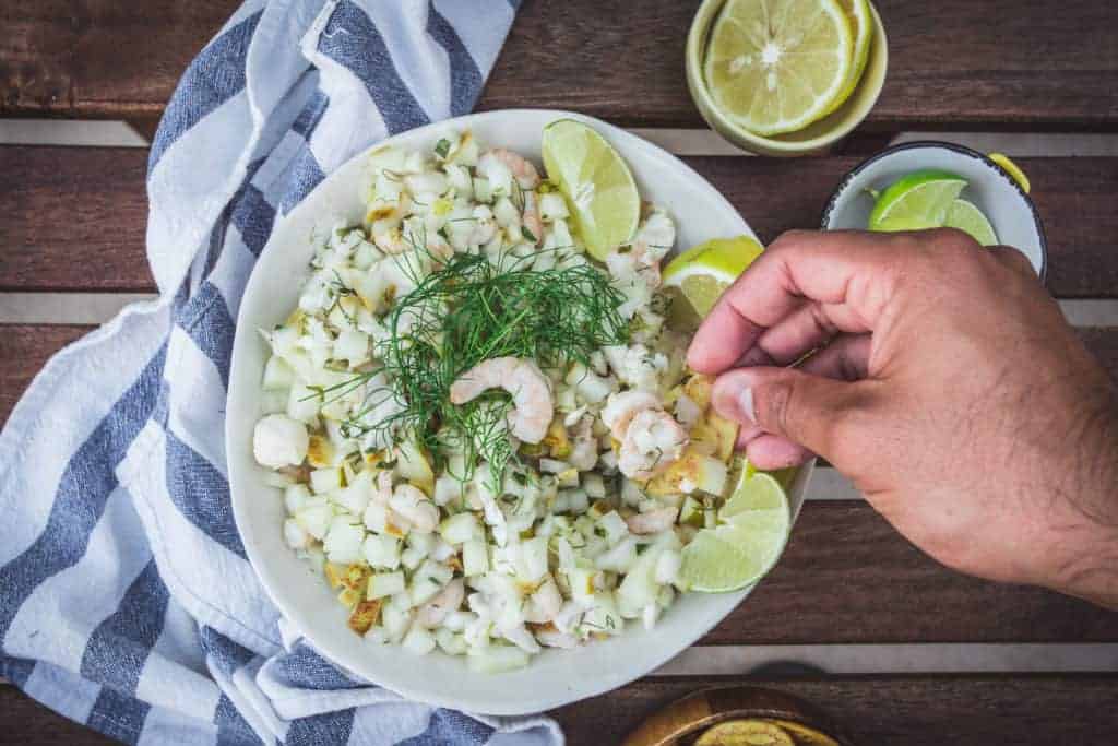 Overhead shot of ceviche in a white bowl.