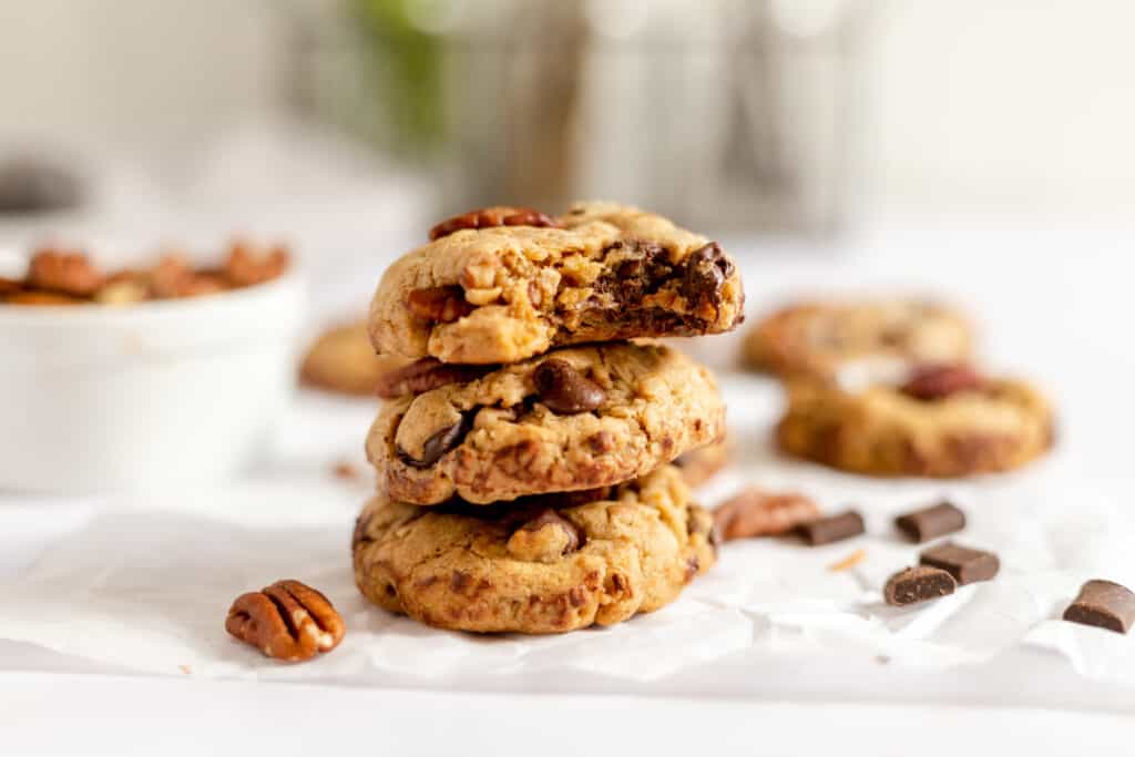 A stack of cowboy cookies on parchment paper.