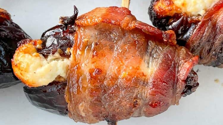Bacon Wrapped Dates with cheese inside with a toothpick through it. 