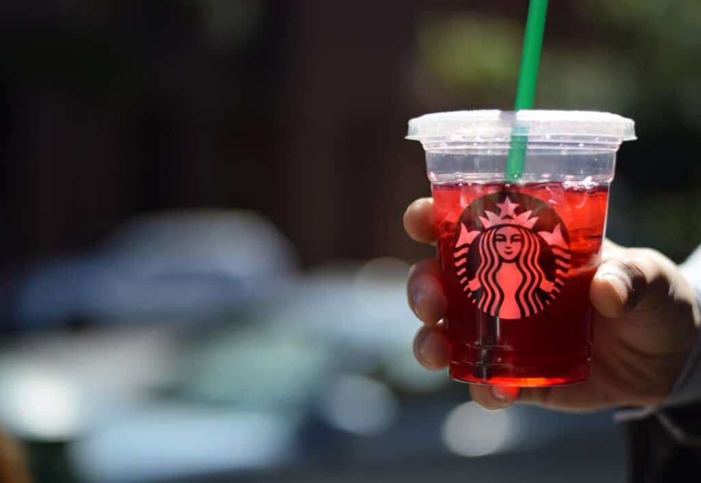 Man holding Starbucks plastic cup.