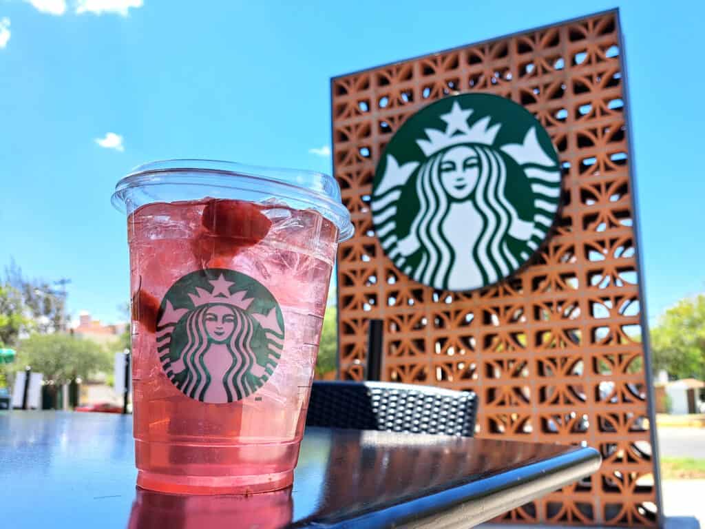 Starbucks refresher with sign in background.