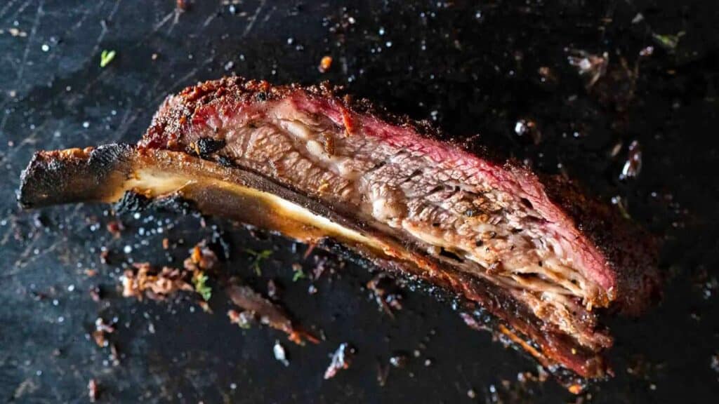 Single sliced dino bone on black background.