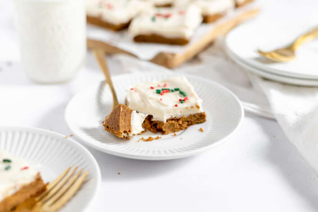 A plate of iced gingerbread bars with red and green sprinkles.