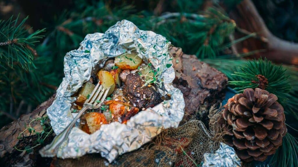 Foil packet with cooked steak and potatoes.