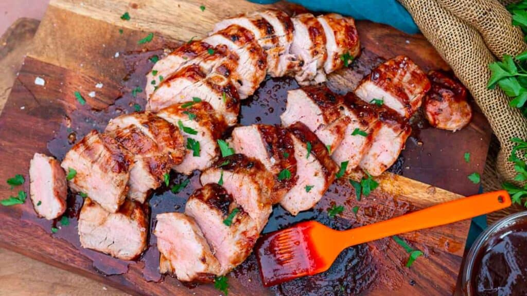 Grilled Pork Tenderloin slices with basting brush.