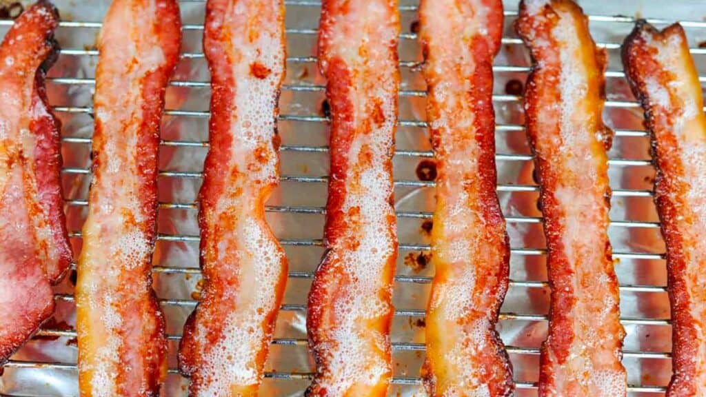 Homemade bacon slices on a rack.