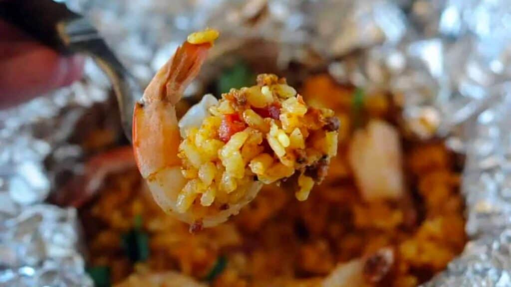 A shrimp with rice paella cooked in a foil packet.