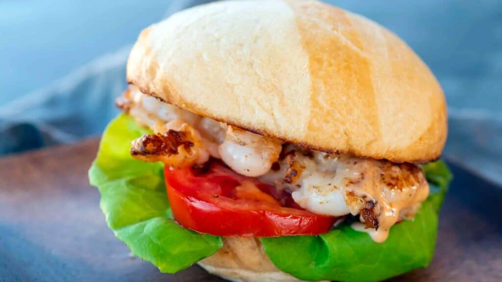 Shrimp smashed and served on bun with lettuce and tomato.