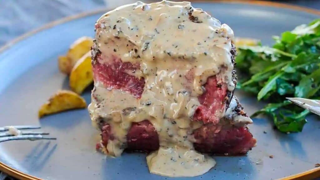 Sliced filet mignon steak with peppercorn sauce.