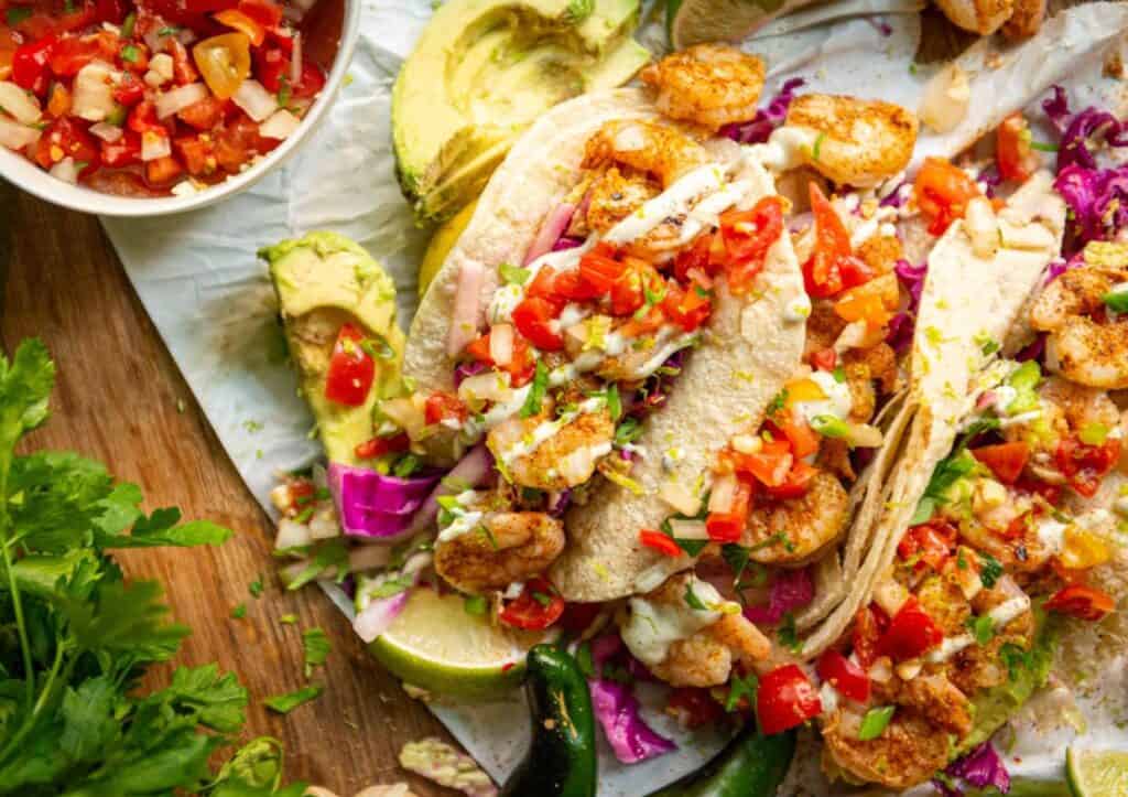 Overhead shrimp tacos lined up and garnished.