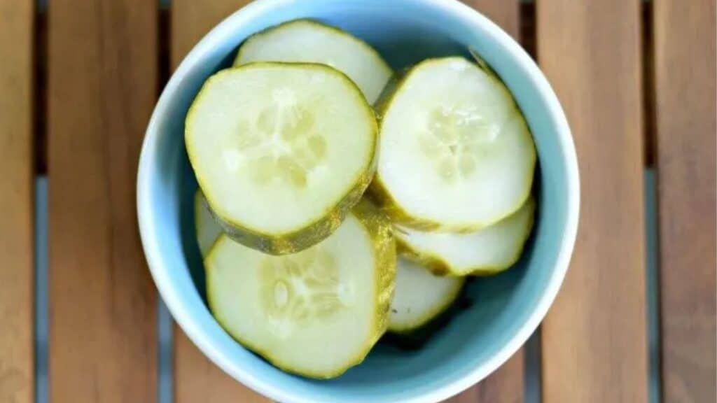 Image shows an overheat shot of homemade garlic dill pickles in a dish.