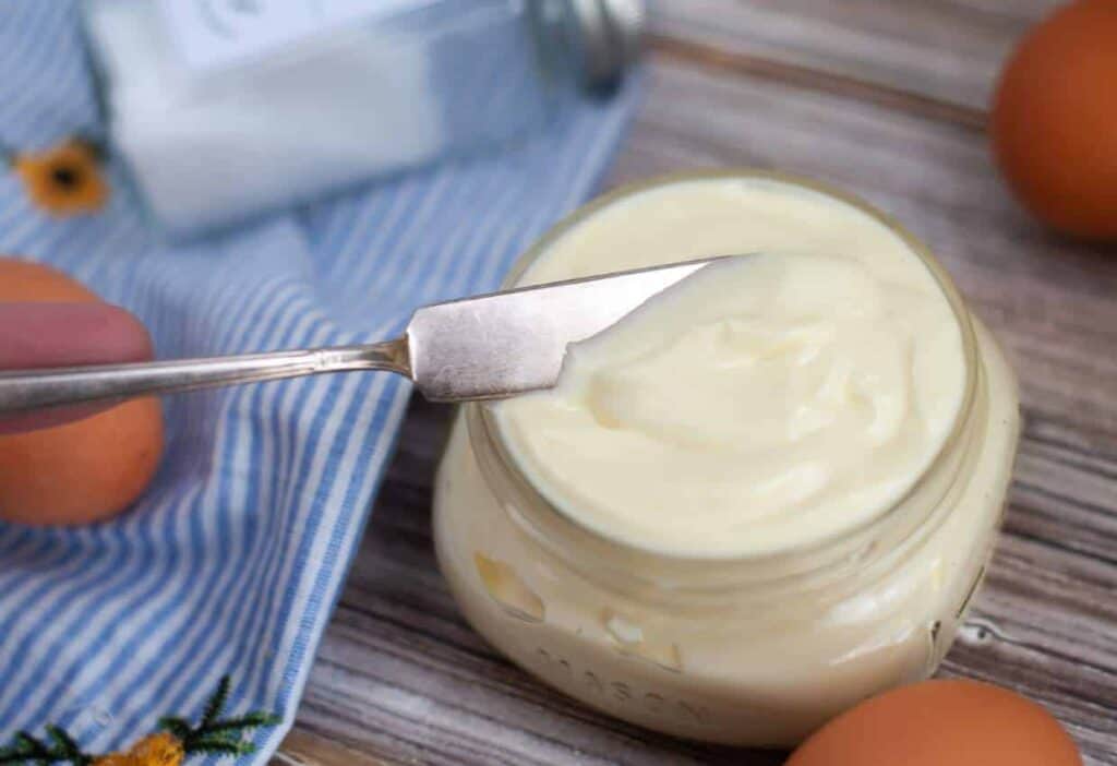 Knife in a small mason jar of homemade mayonnaise.