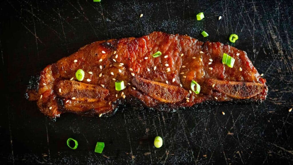 grilled single kalbi rib with green onions.