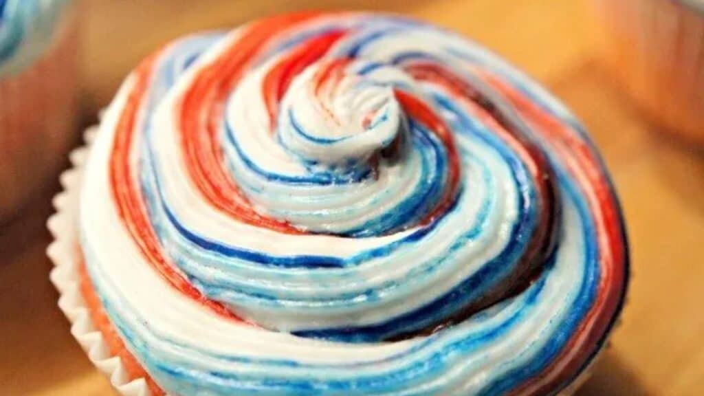 Image shows the top of a Kool Aid Cupcake with swirled frosting.