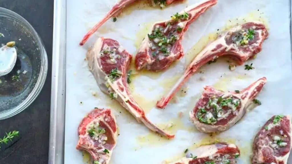 raw lamb chops with herbs and garlic.