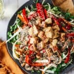 Large plate of fried halloumi salad with wine glass.