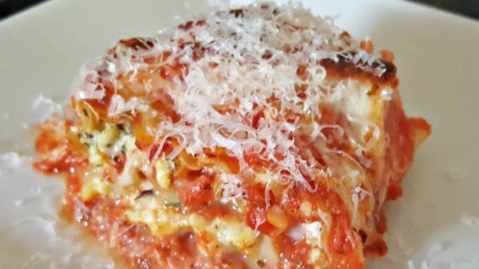 Image shows a lasagna roll up on a white plaet.