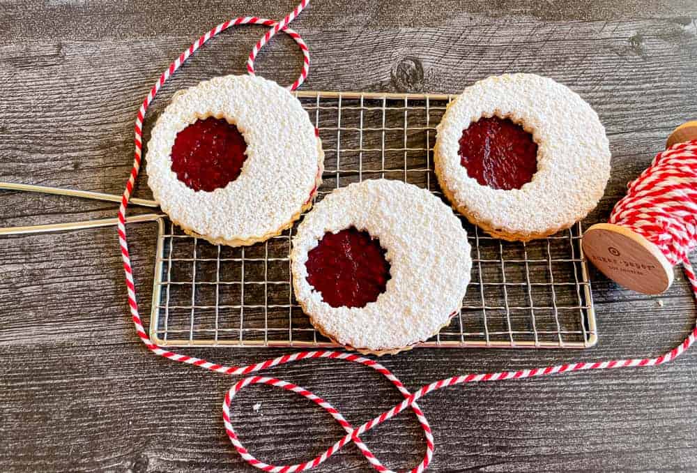 Linzer cookies on a baking tray with baking twine around it.