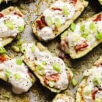 Loaded zucchini boats on a sheet pan.