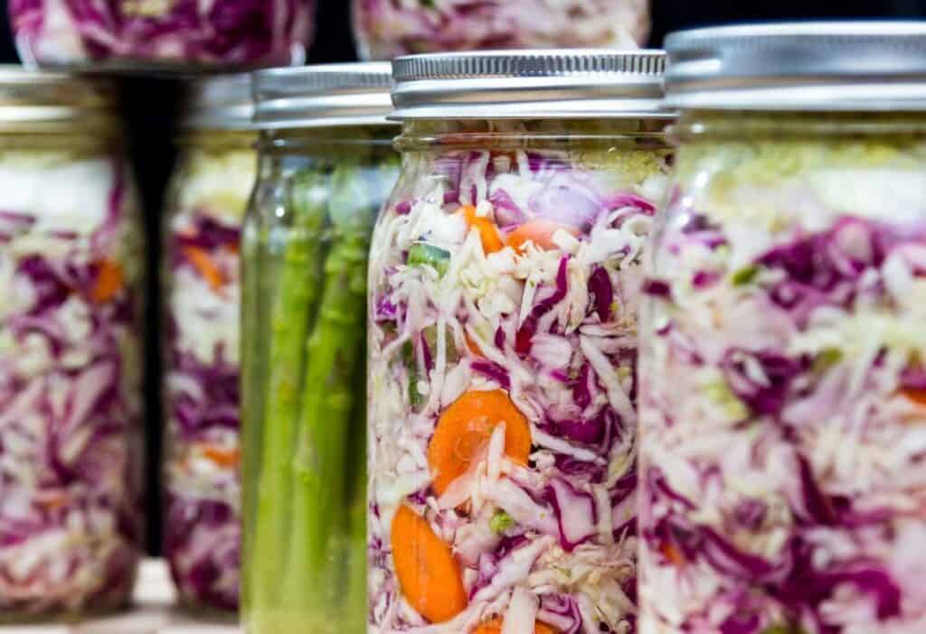 Mason jars of fermenting asparagus and cabbage.