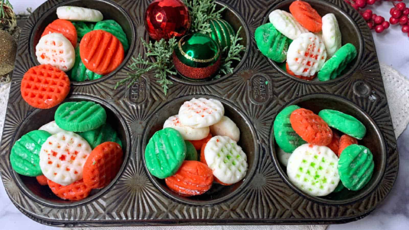 Red, green and white cream cheese mints in a muffin tin.