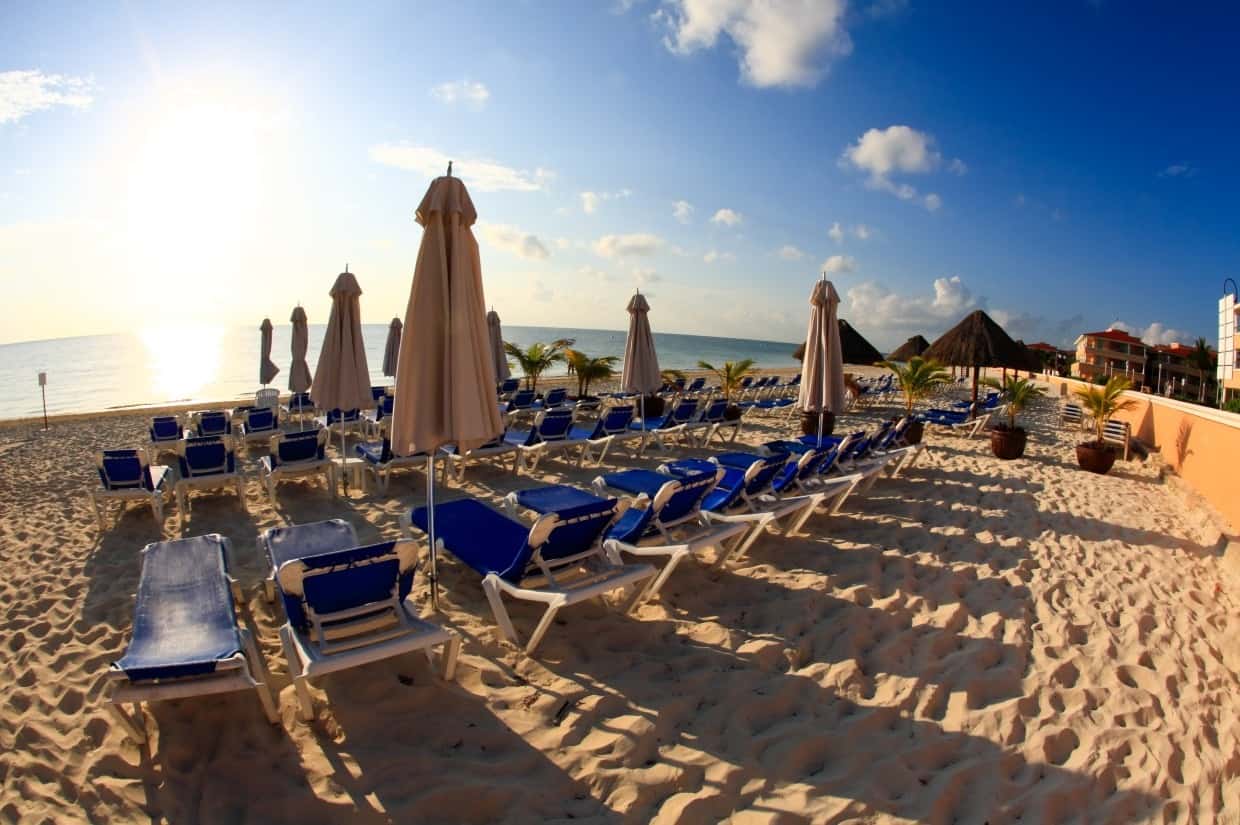 Beach with chairs and down umbrellas near sunset