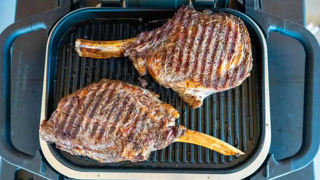 Two cowboy ribeye steaks on the Ninja grill.