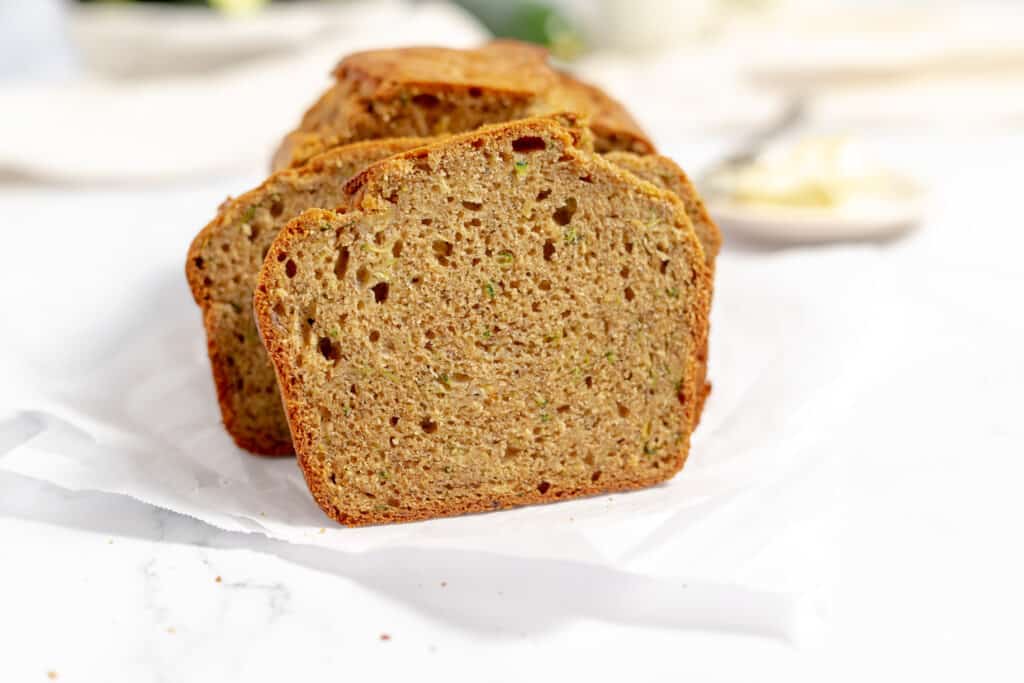 Zucchini Banana Bread sliced on parchment paper.