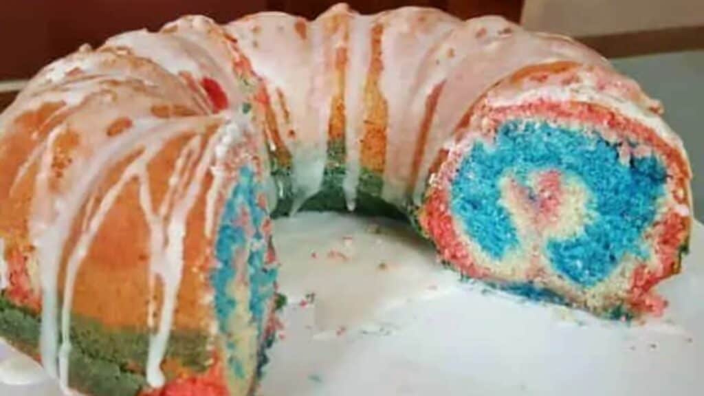 Image shows a Red White and Blue Bundt Cake cut into to show the inside swirl.